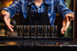 Barman at work,Barman pouring hard spirit into glasses in detail,Bartender is pouring tequila into glass,preparing cocktails,service concept