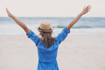 Wall Mural - Young woman enjoying nature on the beach. Vacations concept