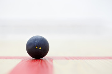 closeup of squash ball on the court