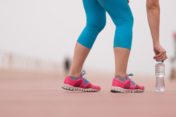 close up on running shoes and bottle of water