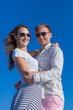 © azazello - Attractive couple in sunglasses posing against clear sky