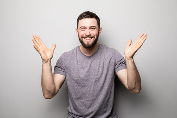 portrait of happy man rise up hands and successful achievement of goals on grey