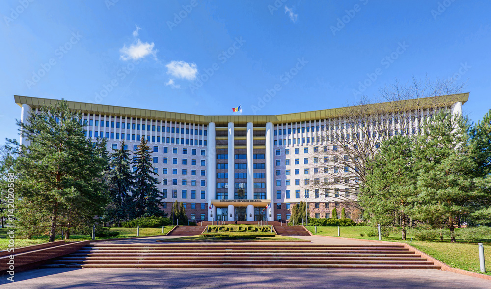 Obraz na płótnie Parliament of the republic of moldova in chisinau, national flag, stefan cel mare street, spring time with blue sky w salonie