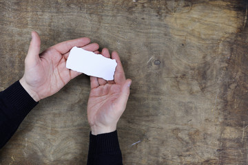 Wall Mural - male hands holding a white blank sheet of paper