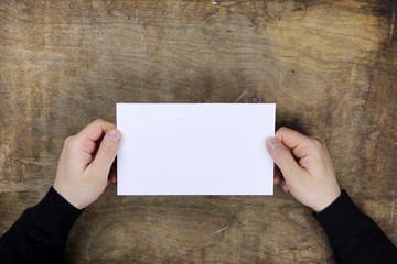 Canvas Print - male hands holding a white blank sheet of paper