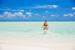 © sborisov - Attractive young woman enjoys Maldivian beach running in the ocean water