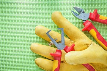 Wall Mural - Yellow safety gloves insulation strippers nippers on green backg