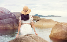 Girl Sitting On The Seaside Rocks