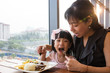 Leinwandbild Motiv Asian Chinese mother and daughter eating steak