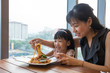 Leinwandbild Motiv Asian Chinese mother and daughter eating spaghetti bolognese