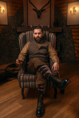 Poster - Hunter man sitting in a chair and drink whiskey