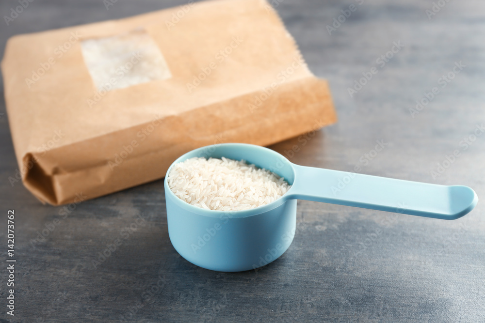 Measure scoop with rice on kitchen table