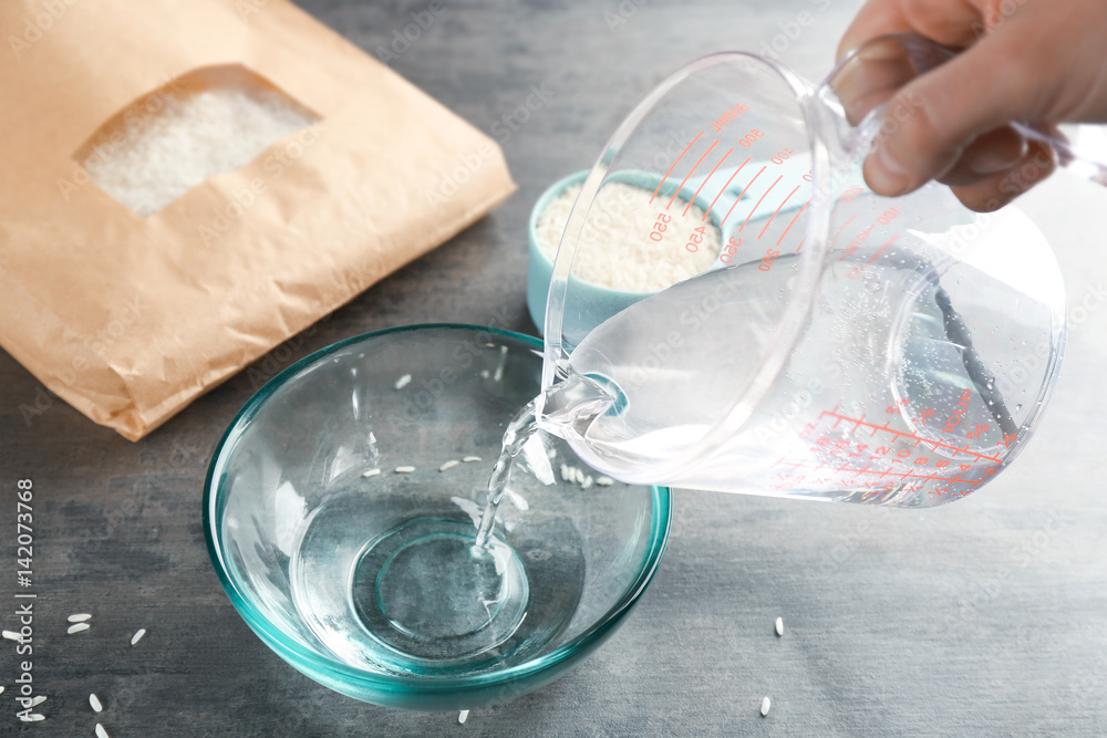 Cooking concept. Pouring water into glass bowl