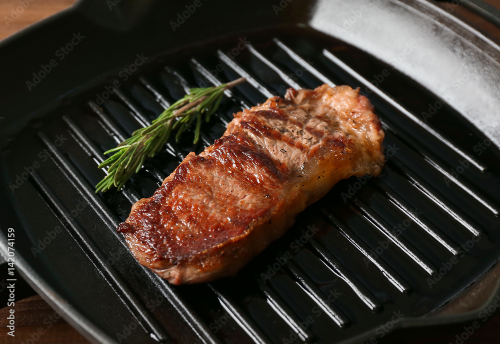 Delicious steak with rosemary on grill pan
