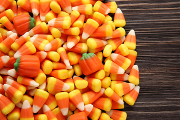 Sticker - Tasty Halloween candies on wooden background, closeup