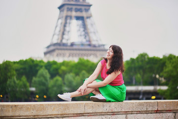 Wall Mural - Young girl near the Eiffel tower in Paris