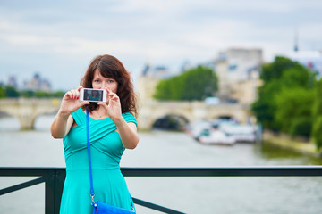 Wall Mural - Young woman with mobile phone in Paris