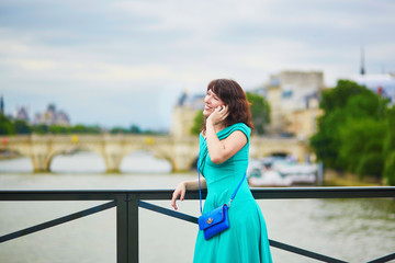 Canvas Print - Young woman with mobile phone in Paris