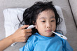 Leinwandbild Motiv Asian Chinese little girl getting measurement for fever temperature