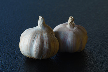 Two bulps of garlic on black table