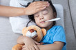 Leinwandbild Motiv Asian Chinese mother measuring little girl forehead for fever