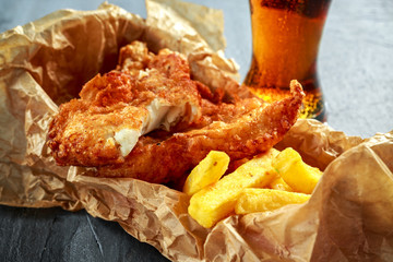 Wall Mural - British Traditional Fish and chips in crumpled paper with cold beer.