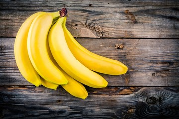 Wall Mural - Bunch of raw organic banana on wooden background