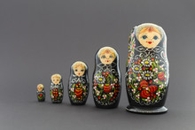 Beautiful Black Matryoshka Dolls With White, Green And Red Painting In Front Of Dark Background