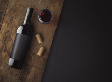 Bottle Of Red Wine With Label On Old Board. Glass Of Wine And Cork. Wine Bottle Mockup. Top View.