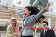 © interstid - Businesswoman crossing the finish line in race competition .Business success in muti culture concept