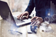 © SFIO CRACHO - Concept of digital screen,virtual connection icon,diagram,graph interfaces.Businessman working at sunny office on laptop while sitting at the wooden table.Blurred background.
