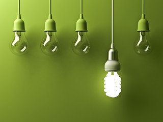 Poster - One hanging energy saving light bulb glowing different stand out from unlit incandescent lightbulbs with reflection on green background , leadership and different creative idea concept . 3D rendering.