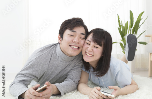 新生活イメージ カップル 室内 リビング 床に寝ながら 頬を寄せ合う 笑顔 Stock Photo Adobe Stock