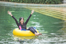Young Woman Enjoying Tubing At Lazy River Pool
