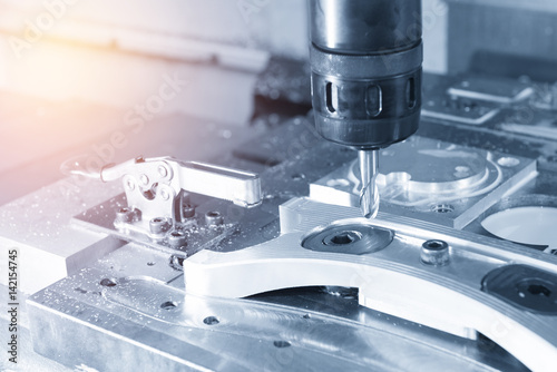 Fotografie, Obraz The CNC milling machine cutting the sample part with the cutting tool in light