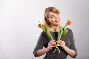 Happy blonde woman with spring flower.