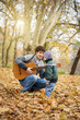 © chika_milan - Brothers having fun in park, playing guitar
