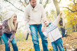 © chika_milan - Caucasian family enjoying an autumn day outdoors, parents trying to teach child how to fly a kite