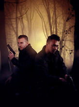 Two Men Holding A Gun In A Forest