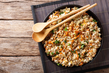 Wall Mural - Thai cuisine: fried rice with minced meat and vegetables close-up on the table. Horizontal top view