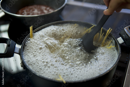 Valokuva Cooking spaghetti in a pot with boiling water