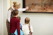 © pressmaster - Teacher pointing at painting in museum while explaining her pupils principles of ancient art