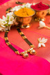 close-up photo of a Mangalsutra or necklace to worn by a married hindu women, with traditional saree or paithani with huldi kumkum and mogra flowers or Jasminum sambac garland