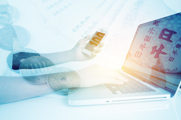 woman's hands with smartphone and typing on notebook with money background