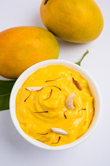 Wall Mural - hapus or alphonso Mango pudding / Mango shrikhand or srikhand or amrakhand - Mango dessert with condensed milk magoes and nuts, selective focus over white background