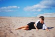 © raisondtre - Portrait of beautiful young woman resting, lying on the beach, on blurred blue sky background