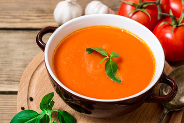 Wall Mural - Tomato soup in ceramic bowl on wooden background.