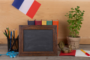 Fototapete - Learning french language concept - blank blackboard, flag of the France, books, pencils, compass