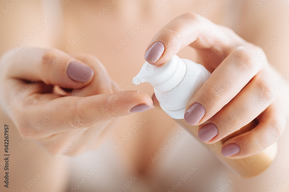woman hands applying moisturizing cream to her skin - obrazy, fototapety, plakaty 