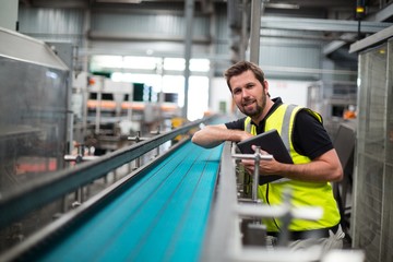 Wall Mural - Portrait of smiling factory worker with a tablet